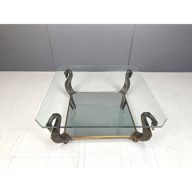 High end vintage brass and glass Swan shaped coffee table. The coffee table consists of 4 swan neck sculptures, which are...