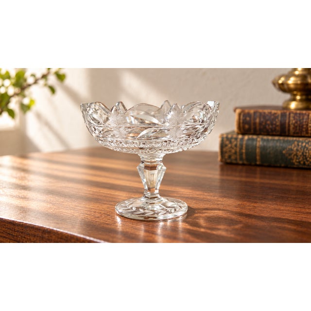 A charming vintage clear cut-glass pedestal compote with a shaped scalloped rim and an elegant combination of wheel-cut...