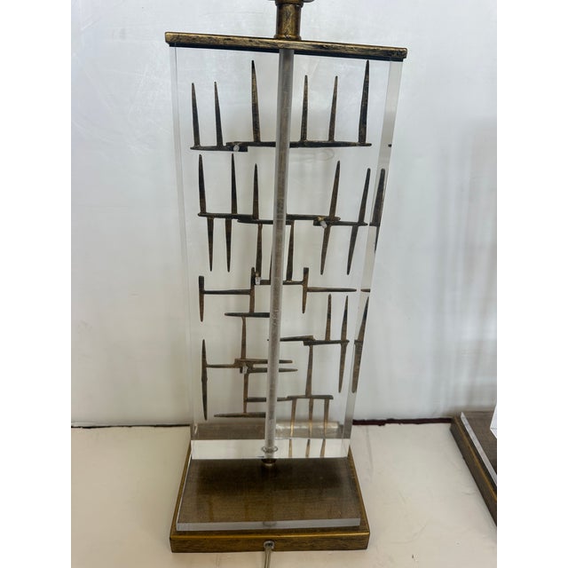 Pair of chic midcentury modern Bruno lucite and metal lamps with interesting sculptural forms imbedded as if floating in...