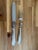 Christofle carving set comprising a carving knife and three-tine carving fork. Reeded silverplate handles bear the oval CC...