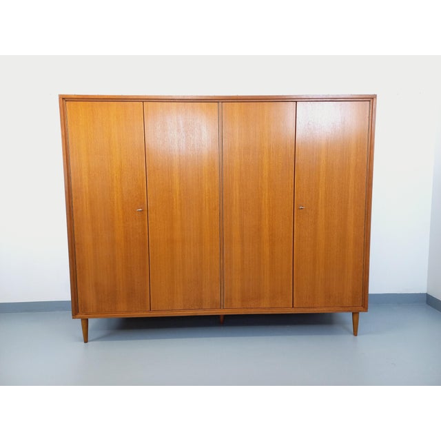 Vintage Scandinavian-style wardrobe from the 1960s, made of teak, with splayed legs and a light wood interior. Ample...