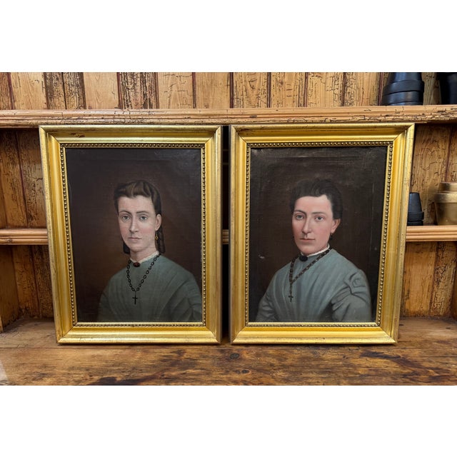 A charming pair of late 19th-century European oil portraits, likely depicting a mother and daughter. Unsigned and painted...