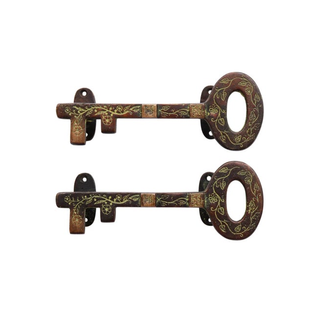 A pair of brass key door handles. Cast in the shape of a simple key etched with vine like floral details. Dimensions per...