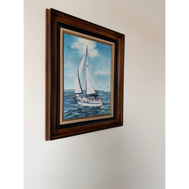 A charming 1970s vintage nautical oil on canvas painting by R. Fisher, depicting a sailboat cruising across open water...