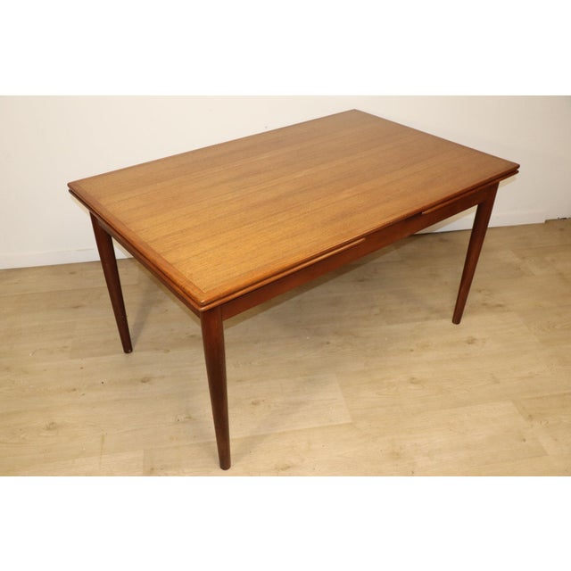 Extendable teak dining table with a clean and refined Scandinavian design. A Danish piece from the 1960s, bearing its...