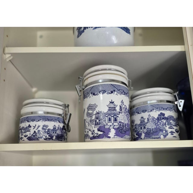 This is a set of three graduated, ceramic kitchen storage canisters featuring the classic Blue Willow chinoiserie pattern....