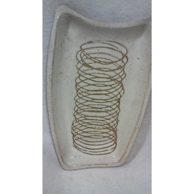 Martz asymmetrical dishes for dining or display in an off white speckled ceramic with an incised scribble design. These...