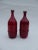 This pair of ceramic vases made by Leon Goossens has red glaze and brown blue glaze on the inside. This piece has an...