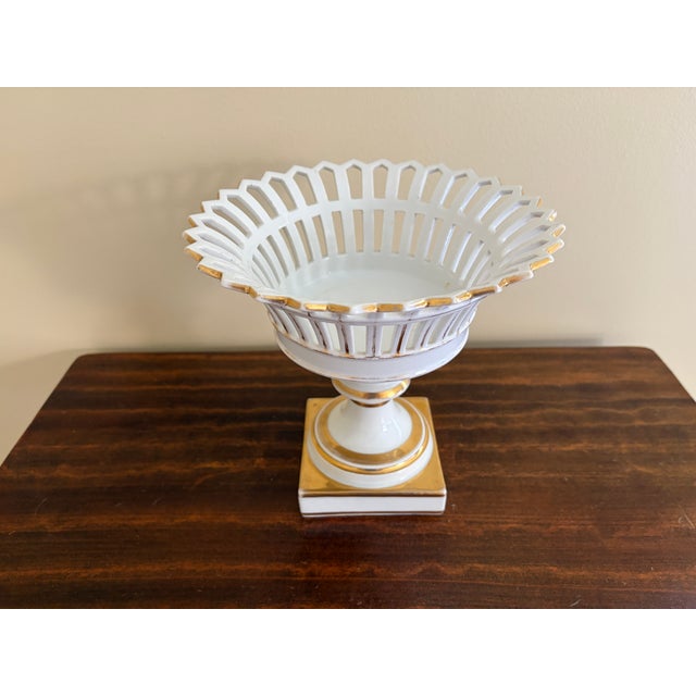 A refined reticulated porcelain basket, executed in a neoclassical idiom with delicate openwork and restrained gilt...