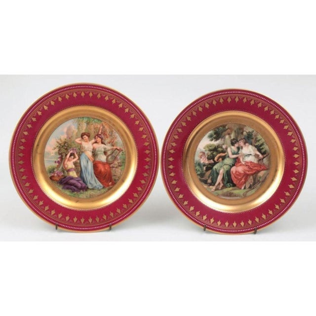 Set of twelve late 19th century Royal Vienna portrait plates with crimson borders, each with different scene, transfer...