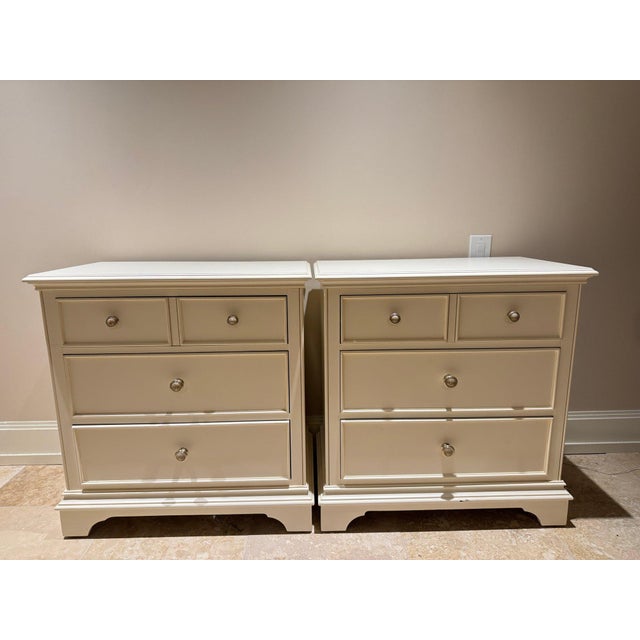 Pair of vintage three-drawer nightstands by Thomasville, finished in a soft white painted tone with classic American...