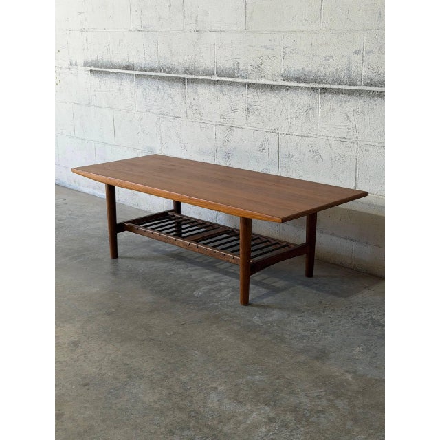 This elegant rectangular coffee table features a beautifully contoured top with subtly tapered edges. The sturdy...