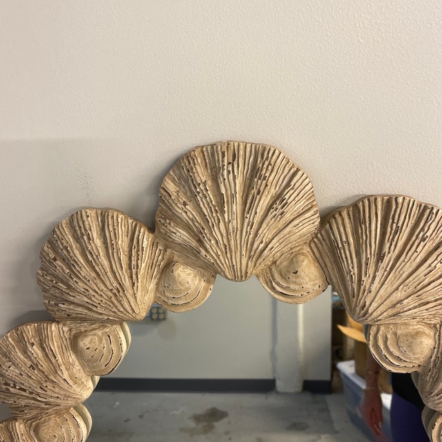 A vintage Palm Beach style oval mirror with a carved scallop shell frame in ivory. The shells are well executed and...