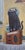This oil on panel painting features a large black cat wearing headphones, perched atop a vintage radio and surrounded by a...