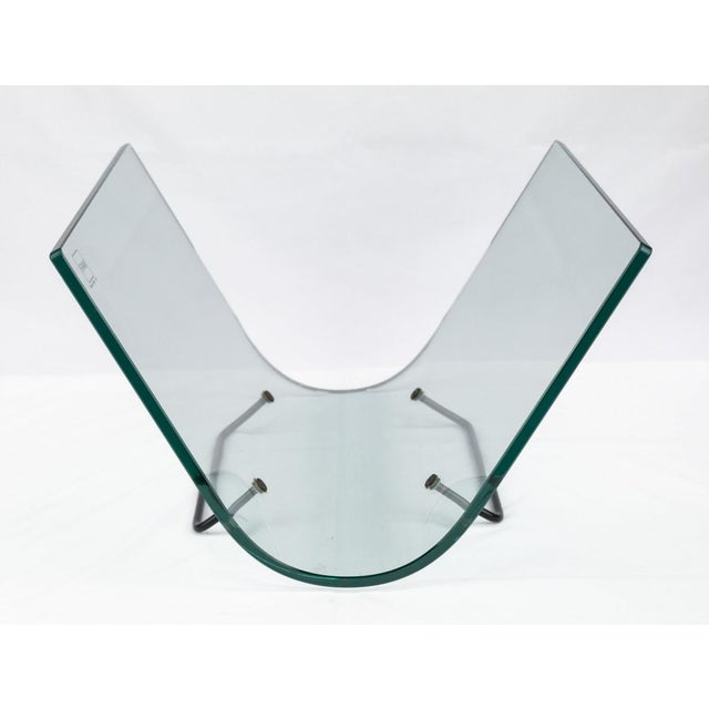 FIAM Italia magazine rack made in the 1980s in curved tempered glass with a black painted steel stand. Overall in very...