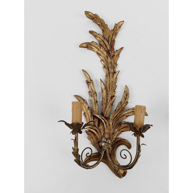 A pair of sconces made in Italy during the mid 20th century but in the Rococo style. The hand-carved lime wood structure...