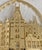This is a Biltmore Estate house Christmas ornament featuring a 24-karat gold finish. The set includes a maroon display box...