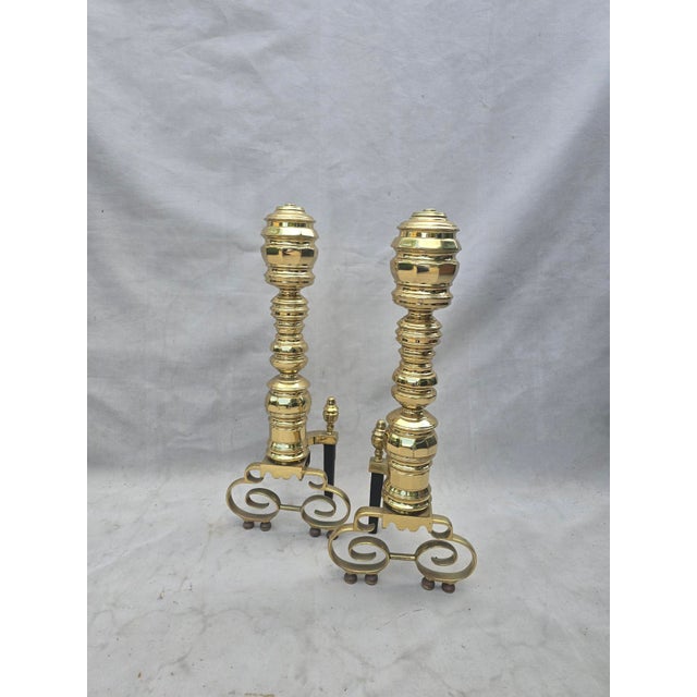 This is a pair of solid brass vintage andirons. They have elaborate column bodies and scroll feet. These would be the...