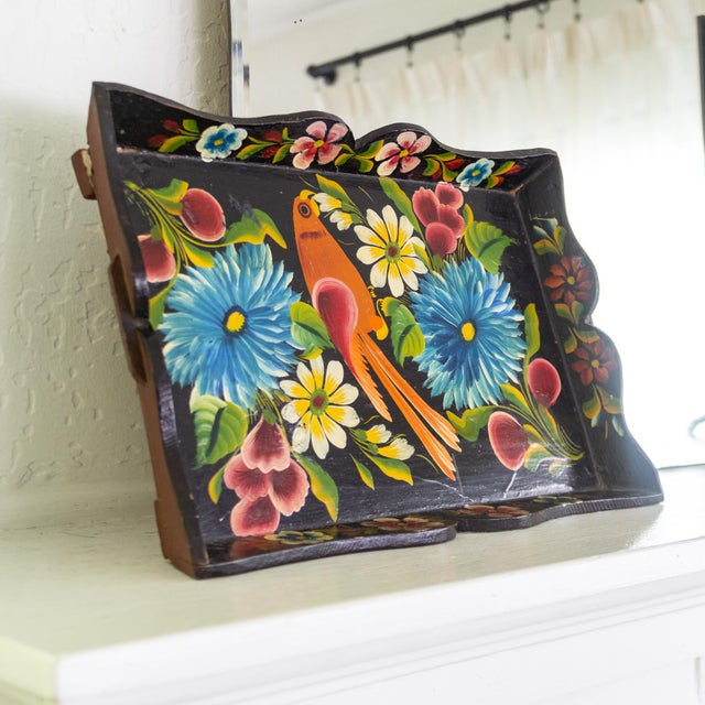 This wooden scalloped tray is hand-painted in a Mexican Folk Art style, depicting flowers and a large bird or parrot in...
