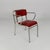 Set of four metal and red faux leather chairs. The frame with armrests is made of curved tubular metal. The backrest and...