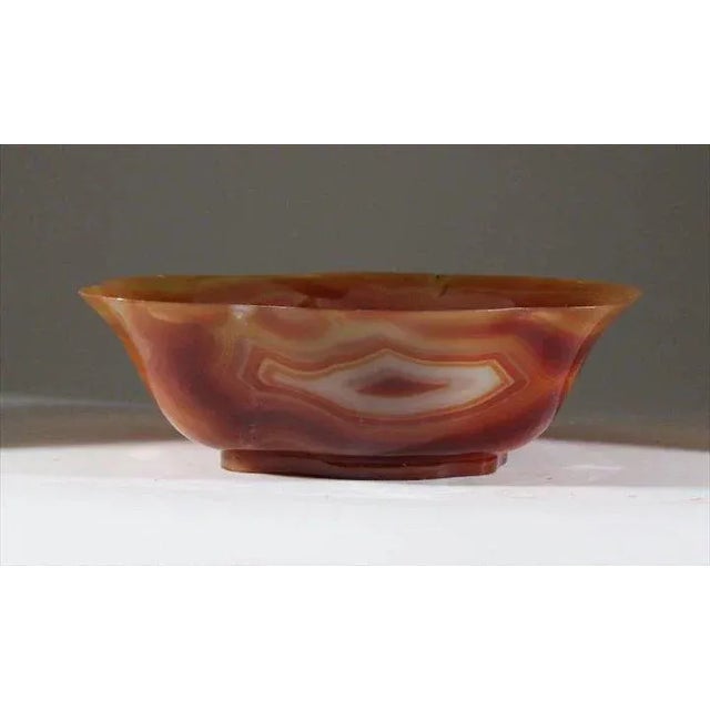 A large carved agate bowl with a beautiful shape rising on a conforming foot. Measures 9 1/8" x 7" x 3" high. Good...