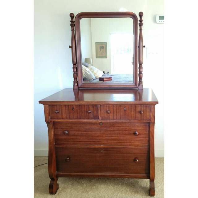 Gorgeous American Empire chest of drawers with mirror resting on turned column supports. The mirror can be moved forward...
