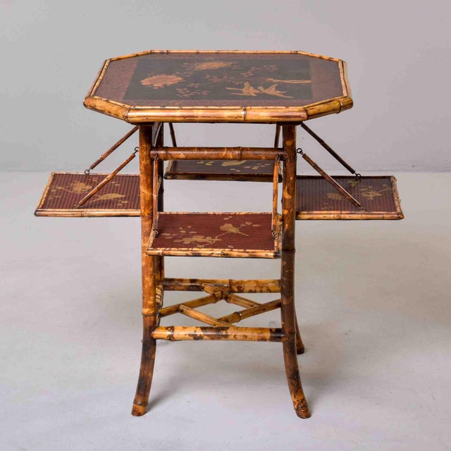 An octagonal bamboo table in a mottled tiger bamboo finish, the top lacquered in chinoiserie style with gilt birds and...