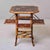 An octagonal bamboo table in a mottled tiger bamboo finish, the top lacquered in chinoiserie style with gilt birds and...