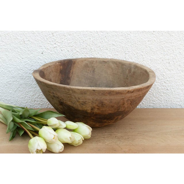 There’s something deeply grounding about holding a vessel carved by hand from a single block of wood. This antique African...