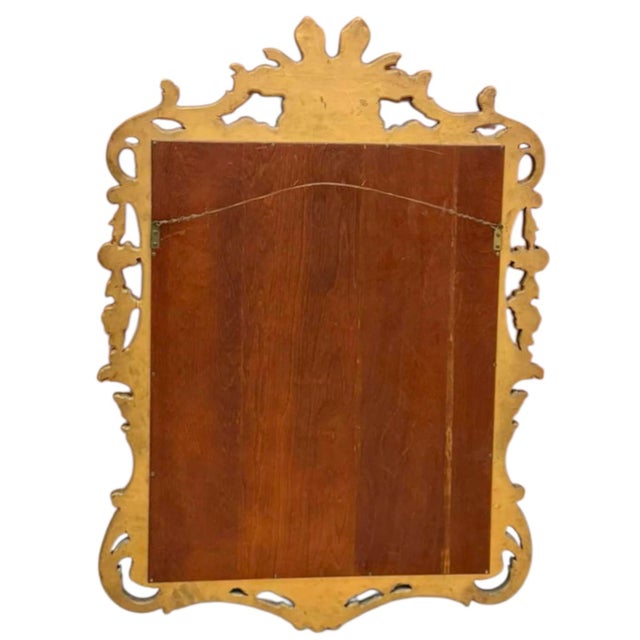 This is a mid-century Italian rococo revival carved giltwood mirror. It features a sort of shooting sunburst pediment, and...