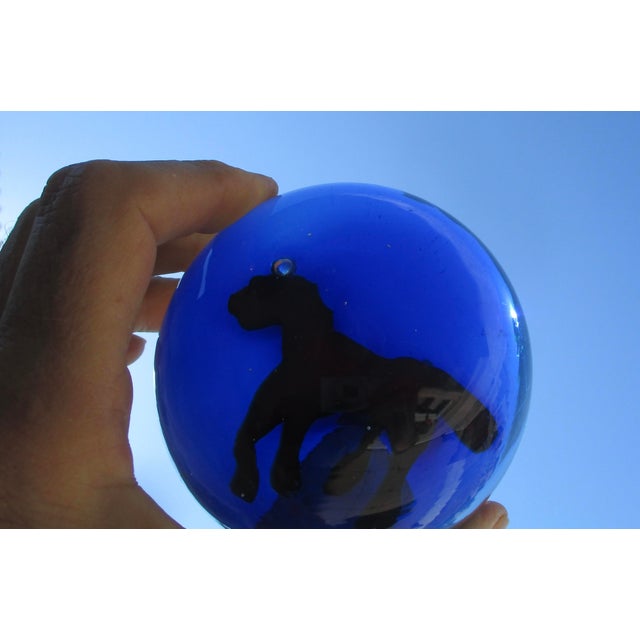 Deep , deep blue glass with a red pony in gallop. The top half is clear, and the lower half is solid transparent blue. The...
