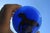 Deep , deep blue glass with a red pony in gallop. The top half is clear, and the lower half is solid transparent blue. The...