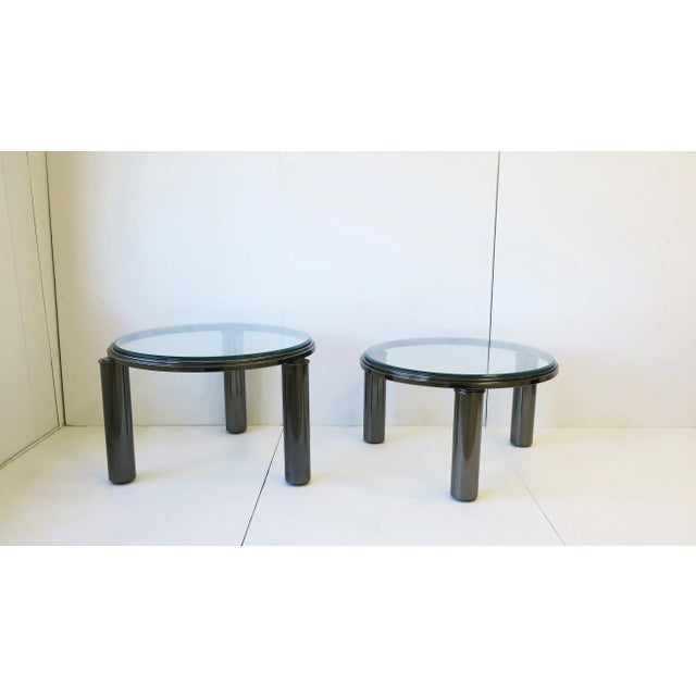 A chic set of two (2) designer 1990s Post-Modern 'smoked' chrome round bi-level cocktail/coffee tables with cylindrical...