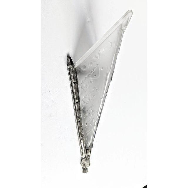A French Art Deco wall sconce in clear frosted molded glass shade with floral motif details. Mounted in a matching...