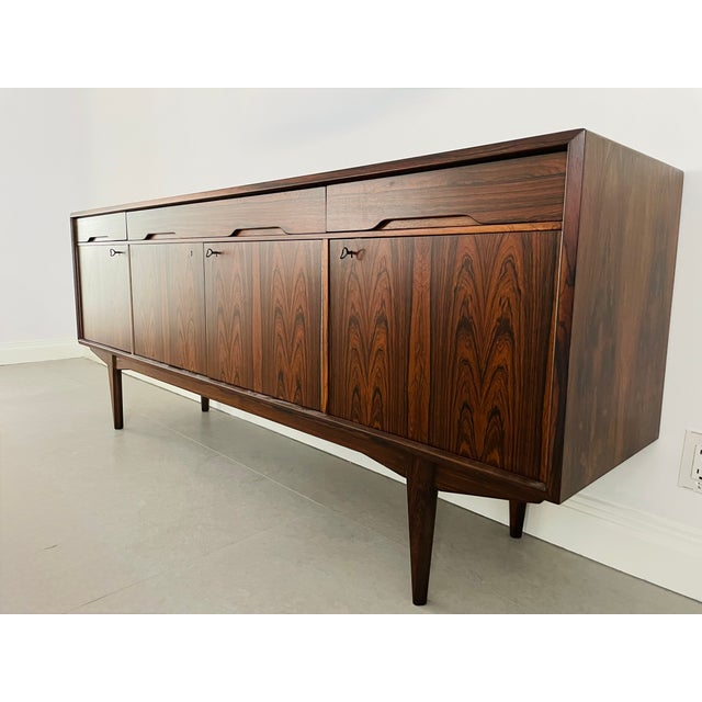 Make a statement with this exceptional Scandinavian Modern credenza, a showpiece with rich, dramatic rosewood grain and a...