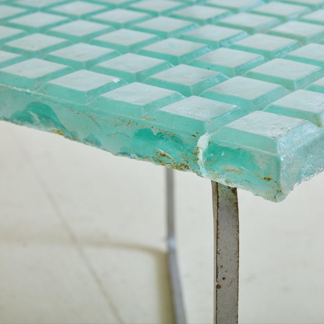 A 1960s Modernist square side table sourced in the South of France. The aqua hued, frosted glass top features a chiseled...