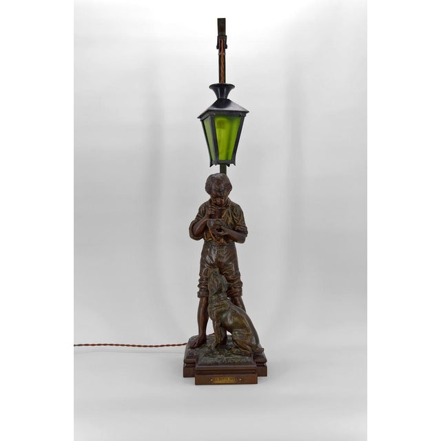 Important patinated spelter lamp representing a young boy, probably a butcher boy, drinking his soup accompanied by his...