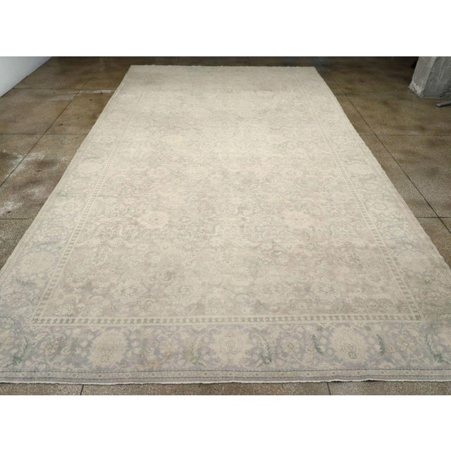 A wool pile of symmetric knots on a cotton foundation. With a significantly reduced palette, the light brown field hosts...