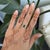 A Zambian emerald in a lush, forest green sits at the center of this solid 14K white gold ring, framed by fourteen earth-...