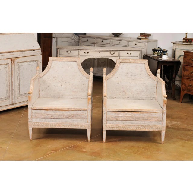 A pair of Swedish Neoclassical style wooden armchairs from circa 1850 with carved guilloche friezes, Classic light gray...