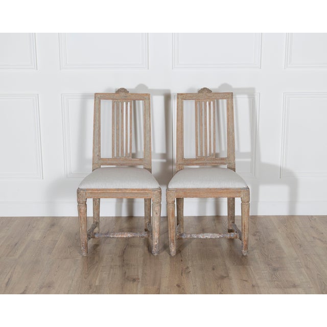 A charming pair of Swedish Gustavian side chairs from the late 18th century, each scraped back to reveal traces of their...