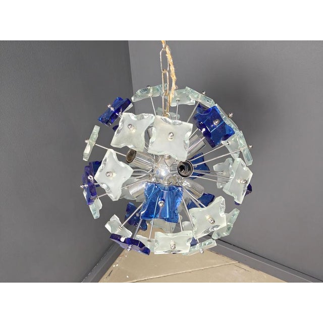 Striking sputnik shaped chandelier with blue hammered glass glasses mounted on a chrome frame. Once illuminated, this...