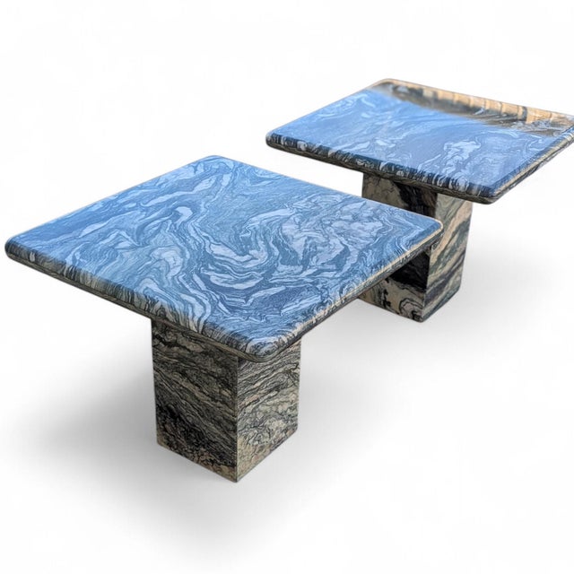 Pair of postmodern green figured marble pedestal side tables with square tops and sculptural stone bases. Each table is...