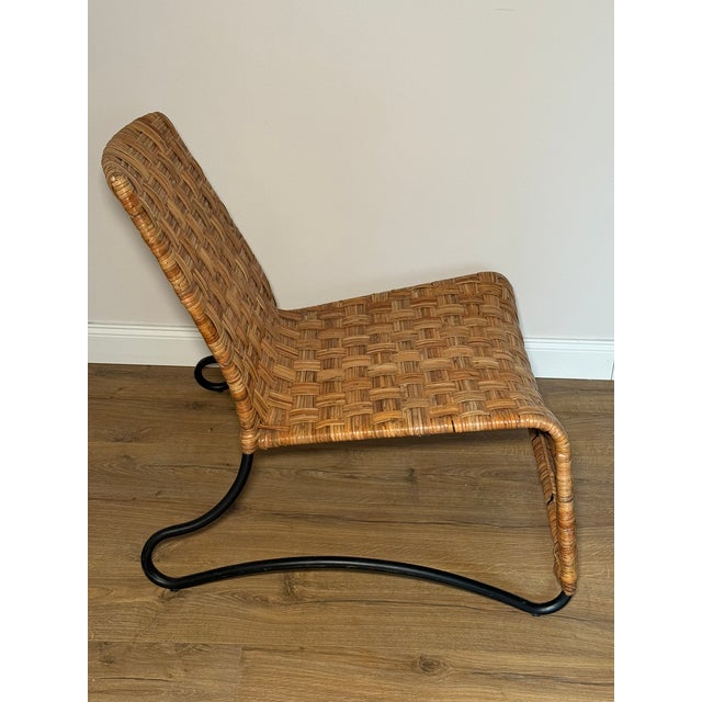 The MÅSÖ chair features a low, sculptural silhouette with a hand-woven rattan body set on a smoothly curved steel frame....