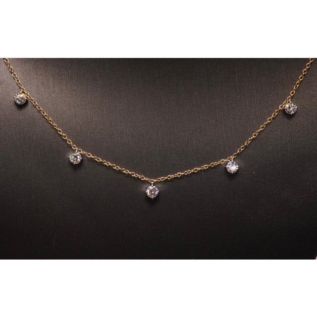 Five round diamonds set in Platinum baskets on 18K Yellow gold chain. Round Brilliant diamonds are F-G VS2-SI1. Total...