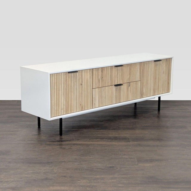 This West Elm entertainment center features a clean, modern design with a white frame and textured wood finished doors and...