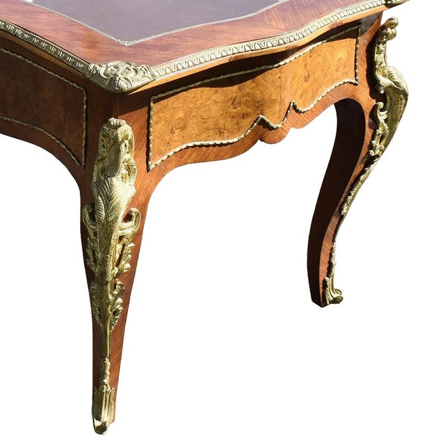The French Louis XV Style Bureau Plat is an antique desk crafted in France in 1955. It features an elegant design with a...