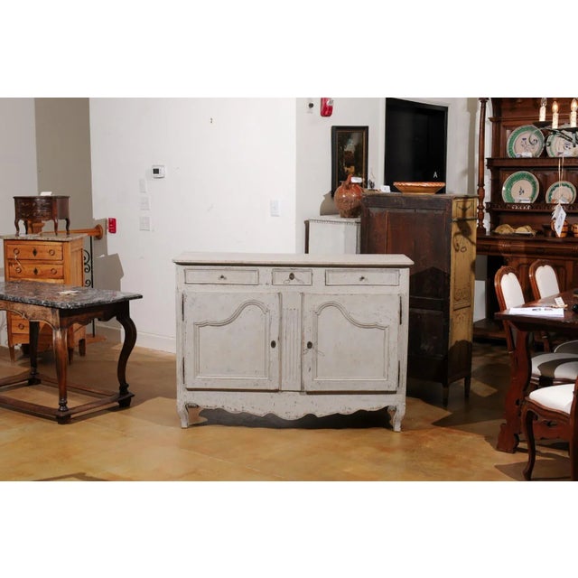A French painted wood buffet from the 19th century, with three drawers, two doors, fluted accents and distressed finish....