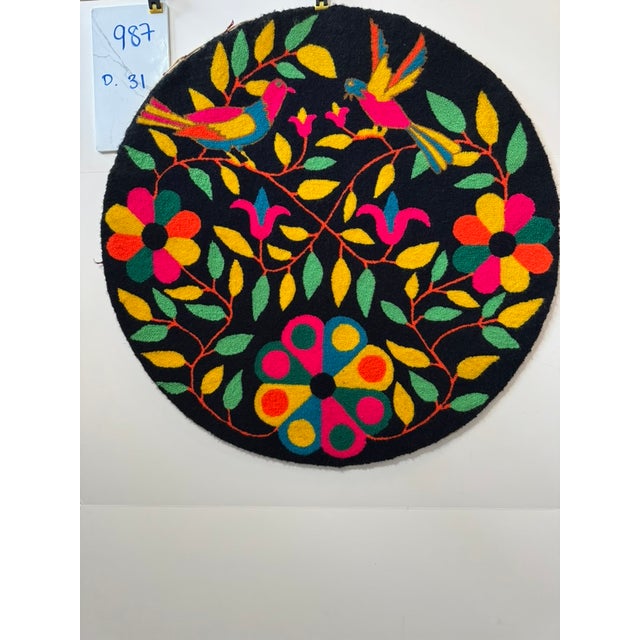 Round hooked textile with vivid folk-art birds and floral design on a black ground. Works as a small accent rug or wall...