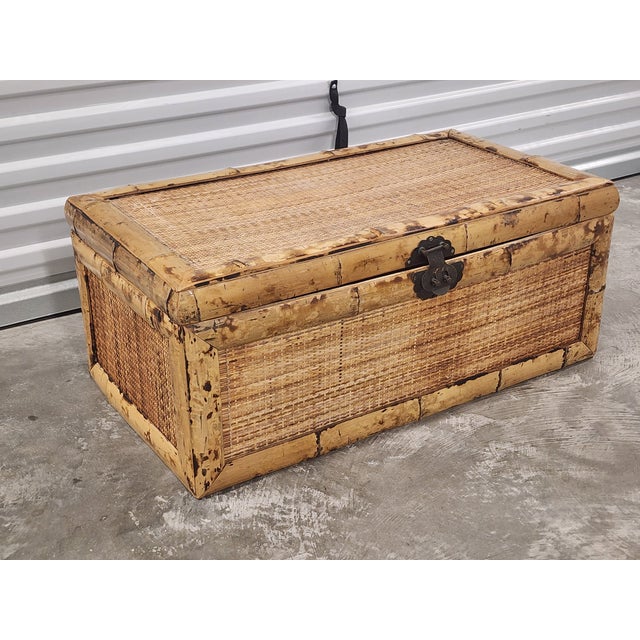 Vintage Mid-Century burnt bamboo and woven rattan trunk with brass Asian inspired hardware. This trunk is a beautiful and...